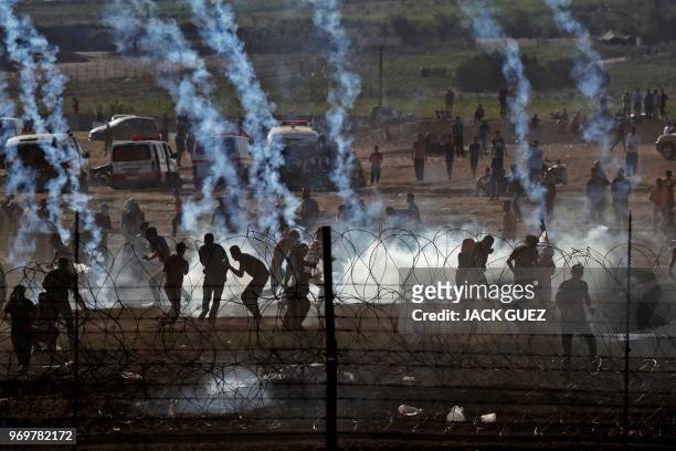 This picture taken from the southern Israeli kibbutz of Nahal Oz across the border with the Gaza Strip shows Palestinian protesters taking cover from...