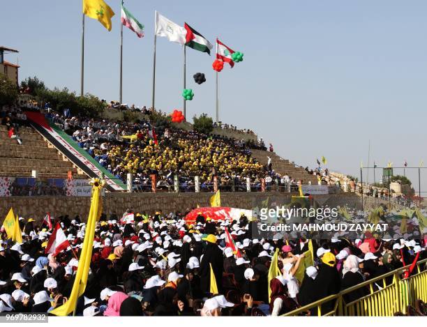Lebanese Shiite Muslims carry flags of the Shiite Hezbollah movement during commemorations marking al-Quds day in the village of Maroun al-Ras, near...
