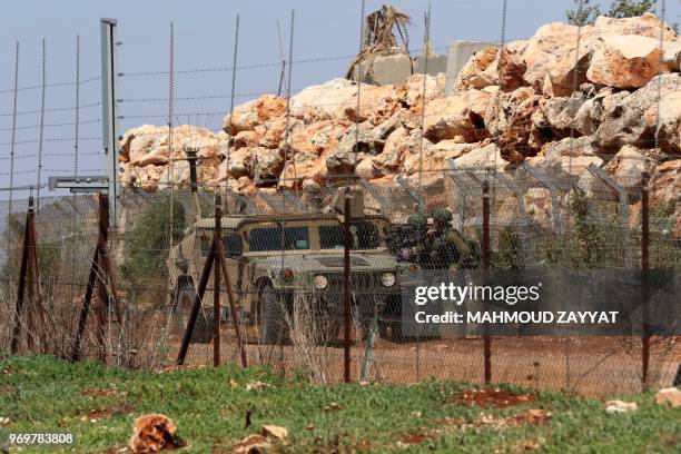 Israeli troops are seen behind the fence seperating Lebanon from Israel as Shiite Muslims commemorate al-Quds day in the village of Maroun al-Ras,...