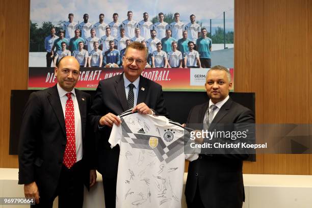 Fernando Carro de Prada, chairman of Bayer Leverkusen and Reinhard Grindel, DFB president hand out a jersey to Adel Ezzat, president of the Saudi...