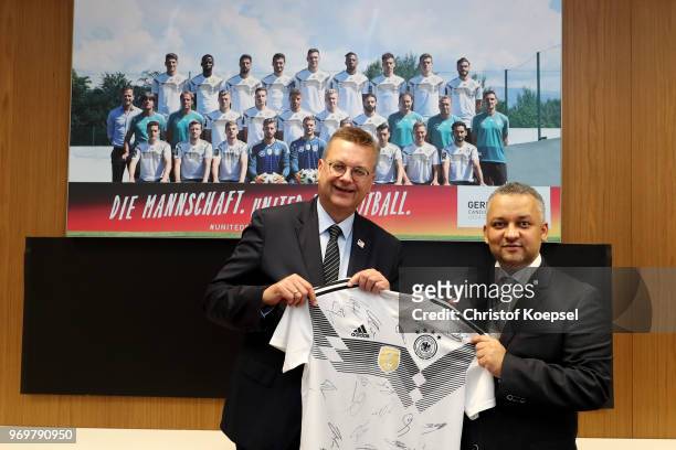 Reinhard Grindel, DFB president hands out a jersey to Adel Ezzat, president of the Saudi Arabia Football Federation prior to the International...