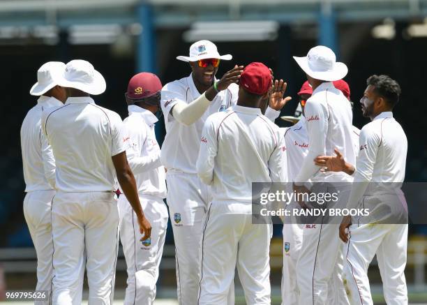 Jason Holder celebrate with Kraigg Brathwaite of West Indies the dismissal of Niroshan Dickwella of Sri Lanka during day 3 of the 1st Test between...