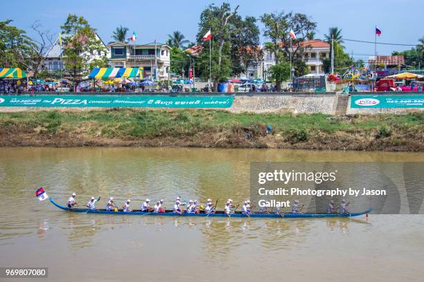 blue longboat moving along the sangkae river in battambang - cambodia water festival stock pictures, royalty-free photos & images