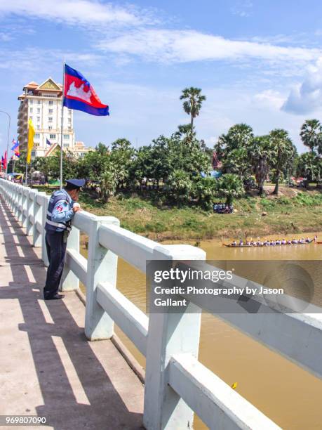 police officer looking out at the boat races in battambang - cambodia water festival stock pictures, royalty-free photos & images