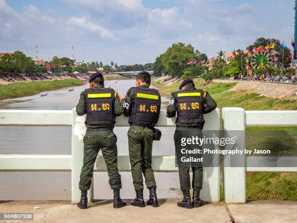 three army men looking at the boat races in battambang - cambodia water festival stock pictures, royalty-free photos & images
