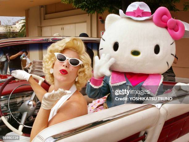 Japan's most popular character Hello Kitty and a Marilyn Monroe look-alike throw kissees to vistors of the Universal Staudios Japan in Osaka, 08...