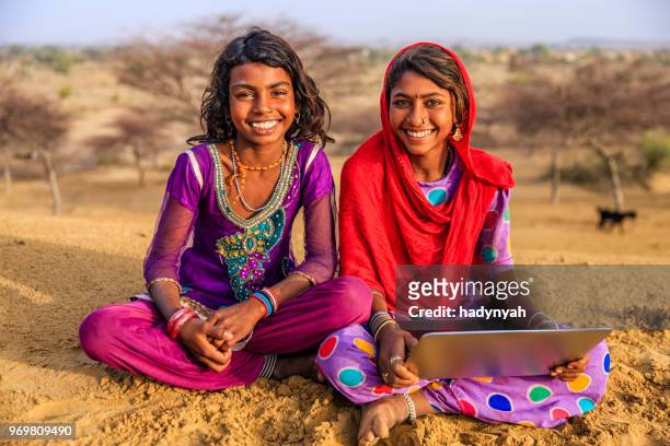 happy indian young girls using laptop, desert village, india - laptop desert stock pictures, royalty-free photos & images