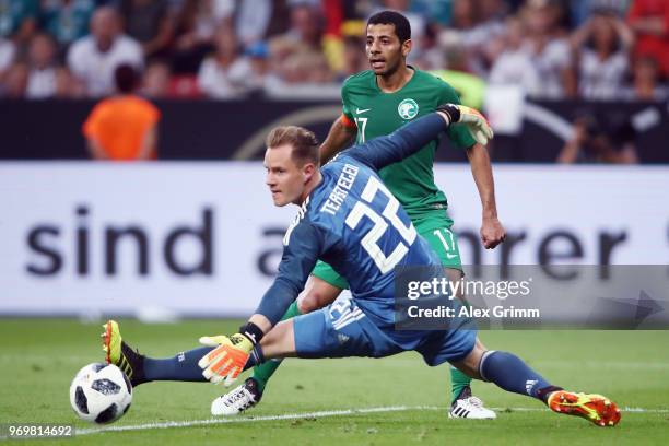 Taisir Al-Jassim of Saudi Arabia passes the ball past goalkeeper Marc-Andre ter Stegen of Germany during the international friendly match between...