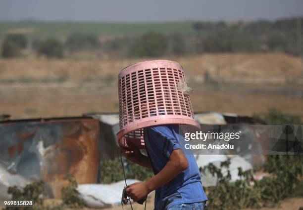 Palestinian man covers his head with a bucket to protect himself form tear gas during "March of the Million for Jerusalem" protests marking the...