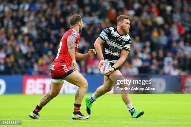 Scott Taylor of Hull FC runs with the ball pursued by Logan Tomkins of Salford Red Devils during the Betfred Super League match between Hull FC and...