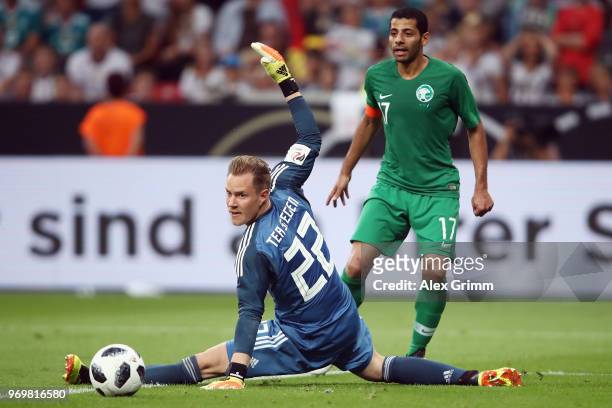 Taisir Al-Jassim of Saudi Arabia passes the ball past goalkeeper Marc-Andre ter Stegen of Germany during the international friendly match between...