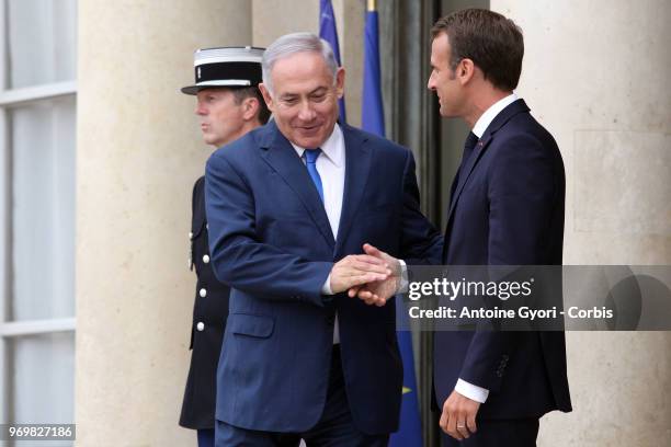 French President Emmanuel Macron accompanies Israeli Prime Minister Benjamin Netanyahu after their meeting at the Elysee Presidential Palace on June...