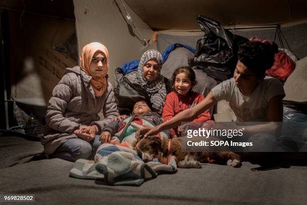 Minah Hose with her kids in their tent in Moria. They left Iraq three months ago. Her son, Leith, was kidnapped there. His captors cut one of his...