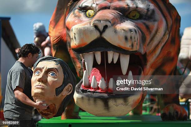 Man carries Elvis Presley's head past a growling tiger as workers put the final touches on dozens of colourful floats to be used next week in Purim...