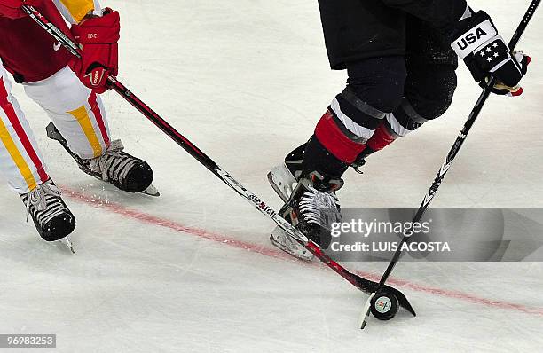 Sticks fight for the puck during the USA vs China women's preliminary Ice Hockey match at the XXI Winter Olympic games in Vancouver's UBC Thunderbird...