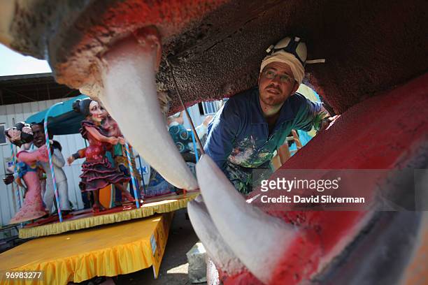 Painter inspects the mouth of an oversized tiger as workers put the final touches on dozens of colourful floats to be used next week in Purim...