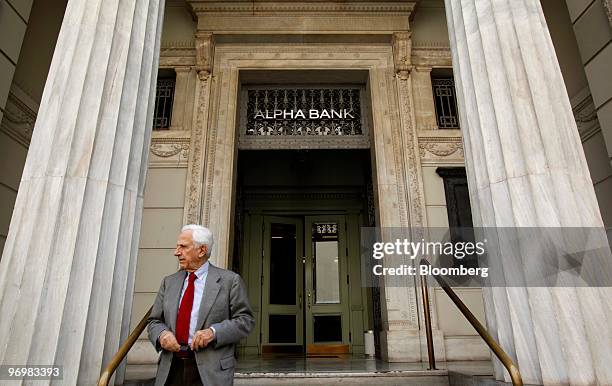 Pedestrian exits a branch of Alpha Bank in Athens, Greece, on Tuesday, Feb. 23, 2010. Greece is not talking to banks about arranging the sale of a...