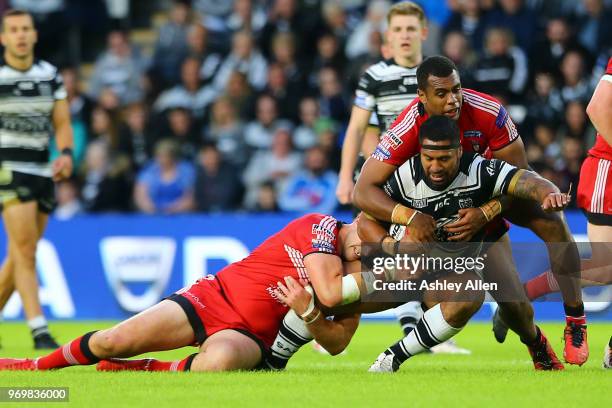 Mickey Paea of Hull FC is tackled by Craig Kopczak and Ben Nakuvuwai of Salford Red Devils during the Betfred Super League match between Hull FC and...