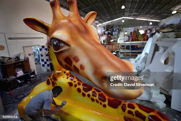 Worker paints the model of a giraffe to be added to one of dozens of large colourful floats for use in next week's Purim carnivals throughout the...