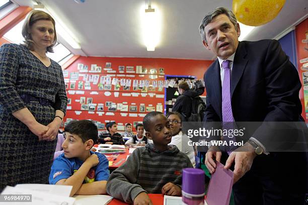 British Prime Minister Gordon Brown center, accompanied by his wife Sarah, right, and Education minister Ed Balls, seated 2nd left, visits a...