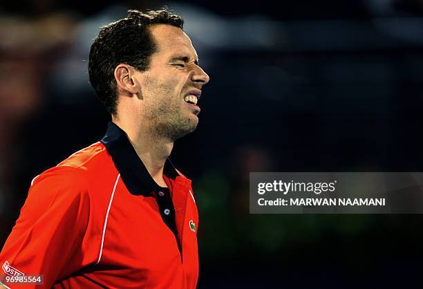 French tennis player Michael Llodra reacts after losing a point to fellow Frenchman Jo-Wilfried Tsonga during the first round of the Dubai Open ATP...