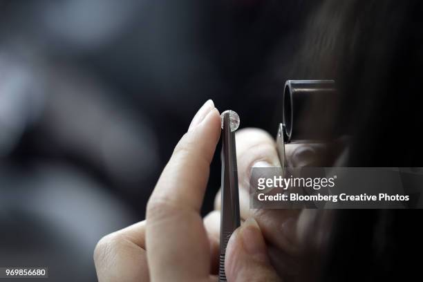 a employee inspects a diamond - diamond gemstone stock pictures, royalty-free photos & images