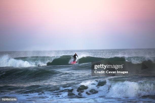 man surfing at beach against clear sky - wilmington north carolina bildbanksfoton och bilder