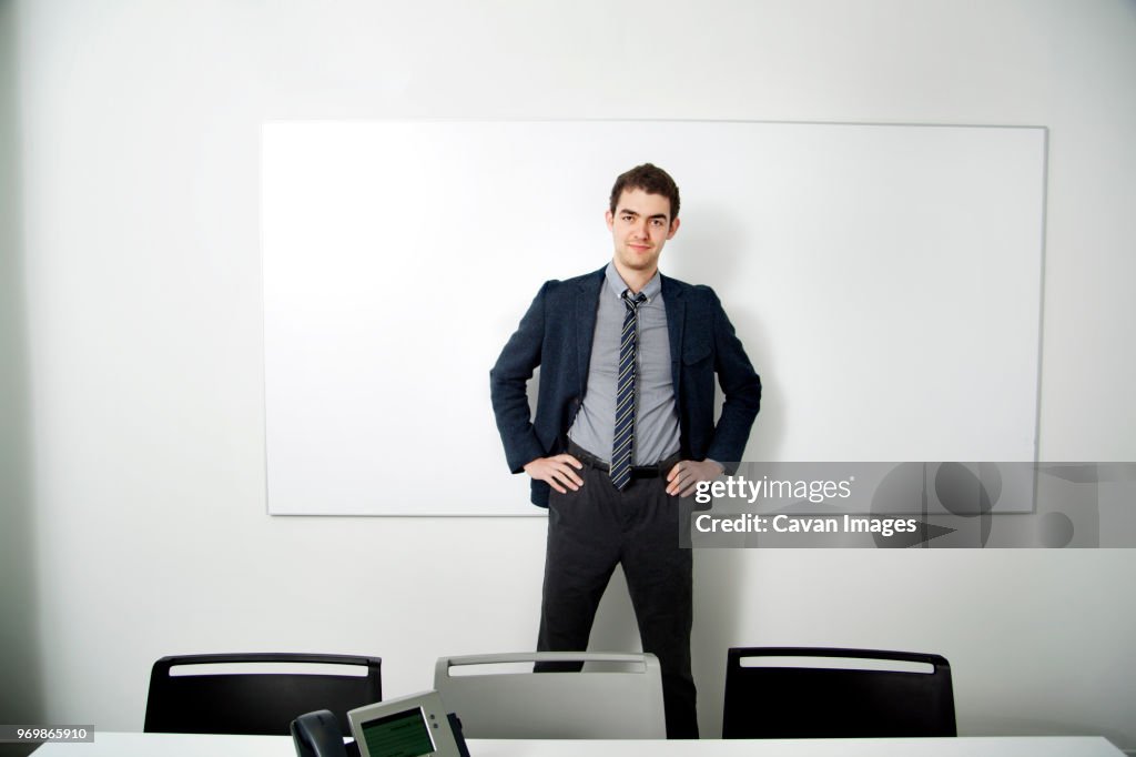Portrait of businessman standing against whiteboard in office