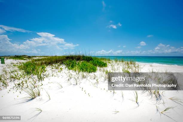 scenic view of sand dunes and sea against sky - pensacola beach stockfoto's en -beelden