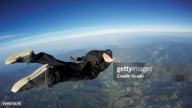 skydiving man jumping over the sea at a sunrise - skydiving stock-fotos und bilder