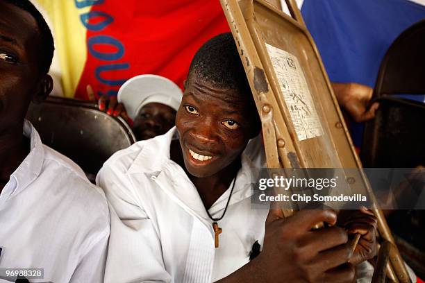 Haitian Voodooists cover their heads with metal chairs after their ceremony for earthquake victims came under attack from Christian residents of the...