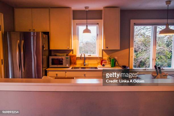 stylish neat clean kitchen at sunset - clean house stockfoto's en -beelden