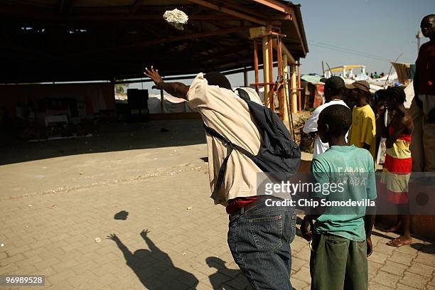 Man throws a rock as a Christian mob attacks a Voodoo ceremony for earthquake victims in the Ti Ayiti neighborhood February 23, 2010 in Cité Soleil,...