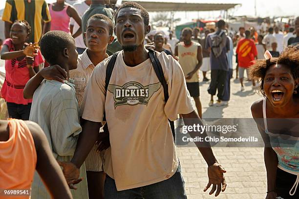 People cheer and shout threats after a Christian mob attacked a Voodoo ceremony for earthquake victims in the Ti Ayiti neighborhood February 23, 2010...