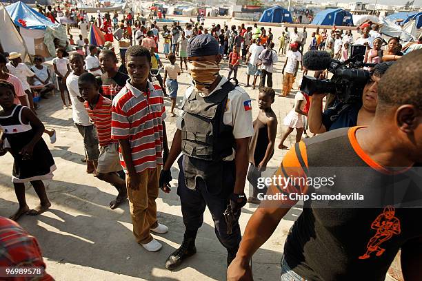 Haitian police attempt to calm a crowd of violent Christians that were threatening to attack a Voodoo ceremony for earthquake victims in the Ti Ayiti...