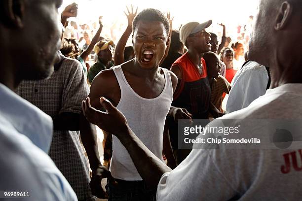 Christian man screams at a group of Voodooists as a mob attacks a Haitian Voodoo ceremony for earthquake victims in the Ti Ayiti neighborhood...
