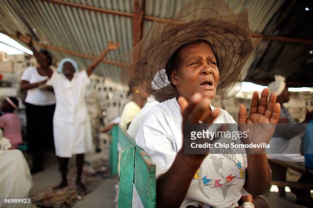 Just paces away from where a Christian mob attacked a Haitian Voodoo ceremony for earthquake victims, an old woman prays in an earthquake-damaged...