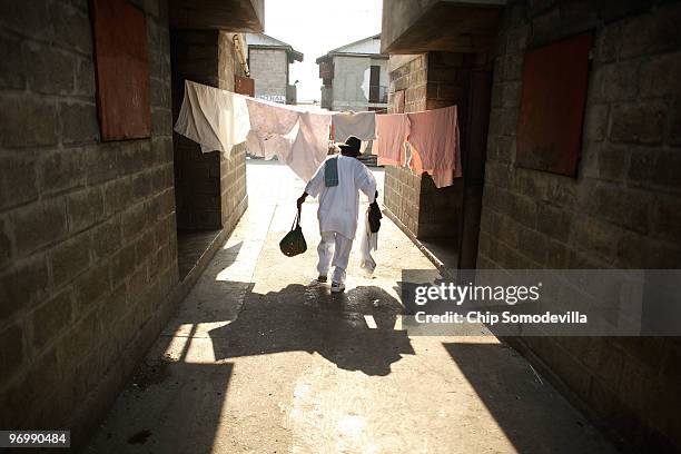 Haitian Voodooist walks under hanging laundry on his way to a ceremony for earthquake victims in the Ti Ayiti neighborhood February 23, 2010 in Cité...