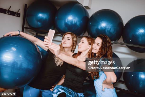 attractive fit females taking selfie in gym - happy caucasian woman on elliptical trainer at gym stock pictures, royalty-free photos & images