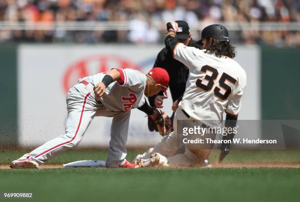 Brandon Crawford of the San Francisco Giants gets caught stealing tagged out by Cesar Hernandez of the Philadelphia Phillies in the bottom of the...