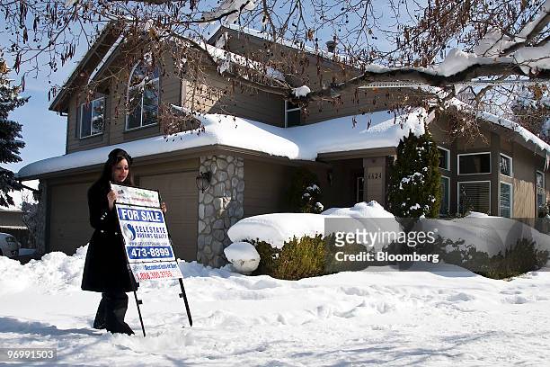 Realtor Sarah Carmona of Sellstate Dreams Realty posts a "Foreclosed: For Sale" sign outside a home in Reno, Nevada, U.S., on Monday, Feb. 22, 2010....