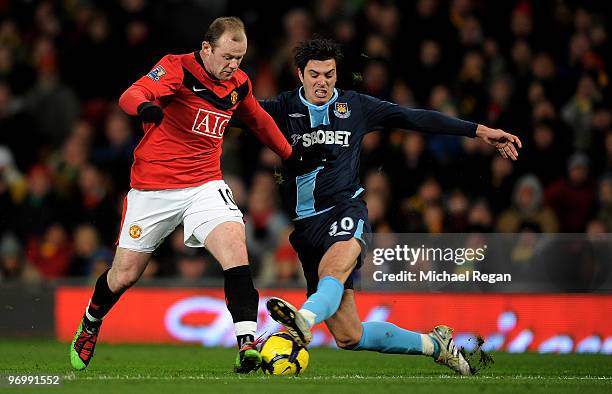 James Tomkins of West Ham tackles Wayne Rooney of Manchester United during the Barclays Premier League match between Manchester United and West Ham...