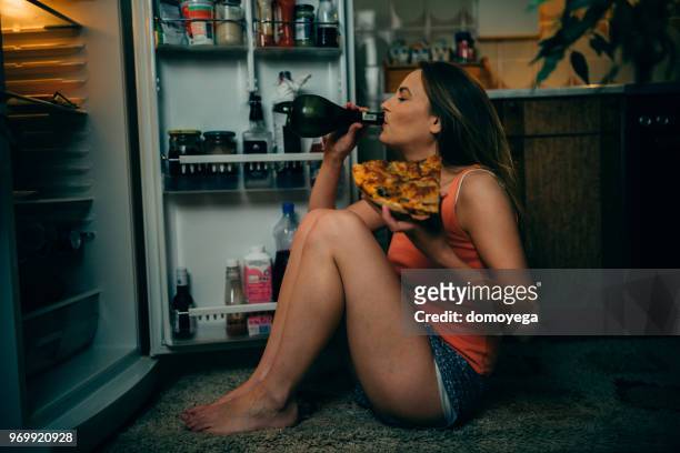 mujer joven comer y beber en la cocina de noche - drunk fotografías e imágenes de stock