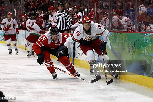 Mathias Seger of Switzerland battles Dmitri Meleshko of Belarus for the puck along the boards during the ice hockey Men's Qualification Playoff game...