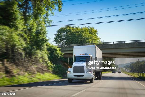 white delivery truck on highway - eld stockfoto's en -beelden