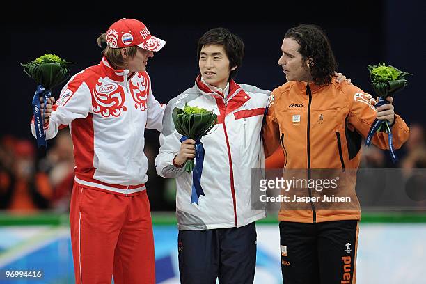 Ivan Skobrev of Russia celebrates winning silver, Lee Seung-Hoon of South Korea gold and Bob De Jong of Netherlands bronze during the flower ceremony...