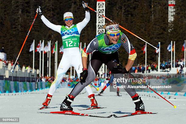 Claudia Nystad of Germany and Anna Haag of Sweden celebrate crossing the finish line during the cross country skiing ladies team sprint final on day...