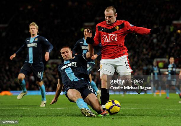 Wayne Rooney of Manchester United is tackled by Matthew Upson of West Ham during the Barclays Premier League match between Manchester United and West...