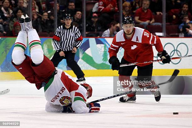 Roman Wick of Switzerland , trips Konstantin Zakharov of Belarus in overtime during the ice hockey Men's Qualification Playoff game between...