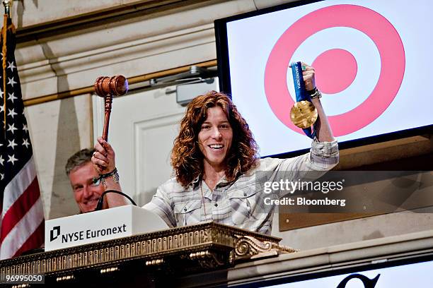 Snowboarder Shaun White, winner of the gold medal in the halfpipe at the 2010 Olympic Games in Vancouver, right, holds his gold medal as he...